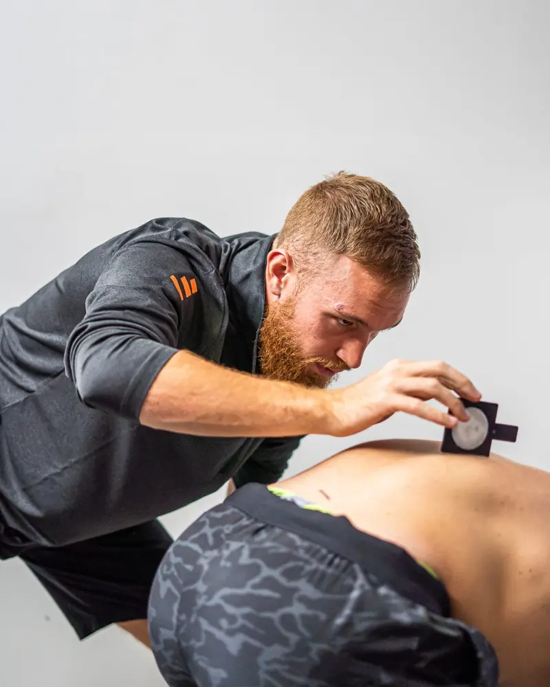 Matt measuring a client's spinal range of motion with an inclinometer