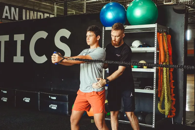 Matt coaching a young athlete through a banded press