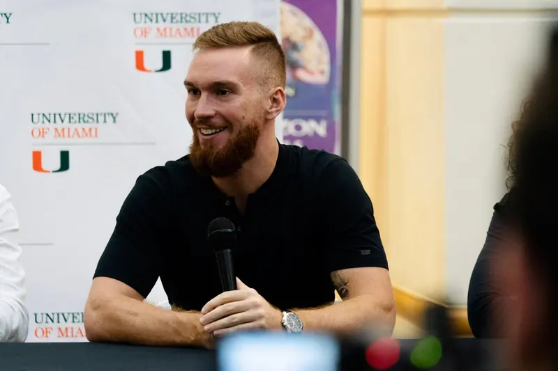 Matt speaking into a microphone on a wellness panel at the University of Miami