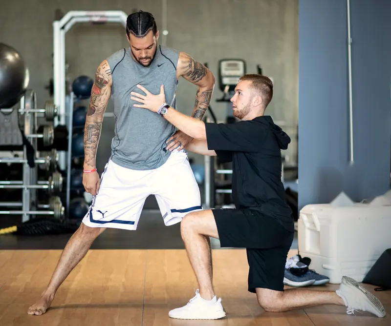 Matt correcting an athlete's lunge position by hand at the Dwyane Wade Invitational